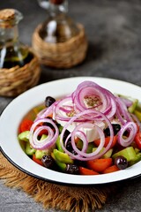 Classic Greek salad from tomatoes, cucumbers, green pepper, red onion with olives, oregano and feta cheese.