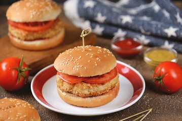 Homemade chicken burgers with tomato.