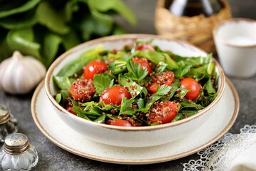 Healthy salad with quinoa, cherry tomatoes and spinach.
