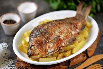 Baked crucian with potatoes and mayonnaise.