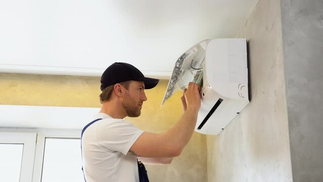 Serviceman is cleaning, repair and maintenance of air conditioner