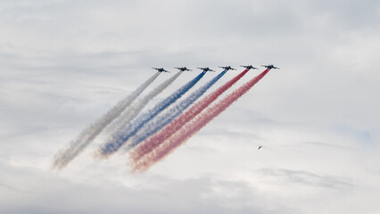  attack aircraft with released smoke in the colors of the Russian flag at the Main Naval Parade in honor of the Day of the Russian Navy in St. Petersburg.