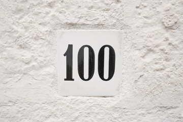 hundred ceramic number plate on white wall