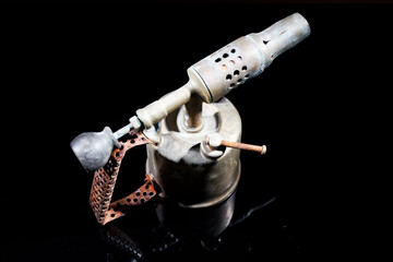 old and vintage blow torch isolated on black background