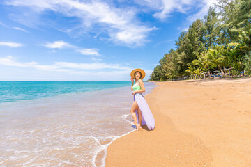 Traveller woman in swimwear enjoys tropical beach vacation. Summer lifestyle of pretty happy young...