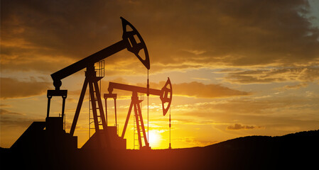 The change in oil prices caused by the war. Oil price cap concept. Oil drilling derricks at desert...