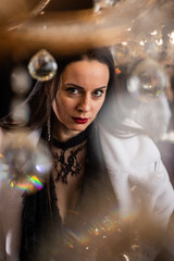 Brunette with red lipstick in a white fur coat on the background of a chandelier