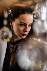 Brunette with red lipstick in a white fur coat on the background of a chandelier