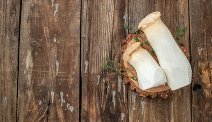 Fresh raw mushrooms, king oyster or eringi on a wooden background, banner, menu, recipe place for text, top view