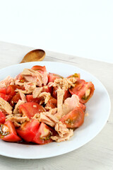 Tomato from the garden with tuna on a white plate