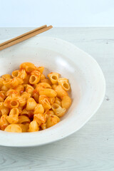 Pasta of snails with tomato on a white plate