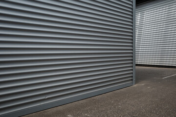 Low angle and exterior view in front of closed storefront, and closed roller shutter door, at the...