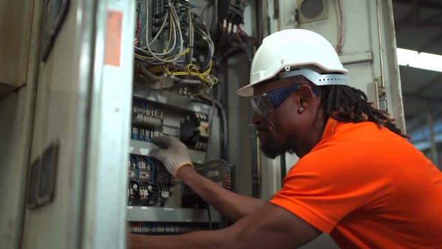 Maintenance engineer repairing a fuse box and electrical circuit.