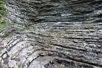 The walls of the gorge, crafted by nature's hand over centuries, showcase intricate layers of sedimentary rock, displaying a rich tapestry of earth tones and jagged edges and crevices 