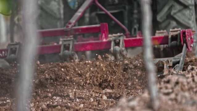 close up of soil aeration with tractor. Blades of a rototiller working the land, agriculture, slow motion close up
