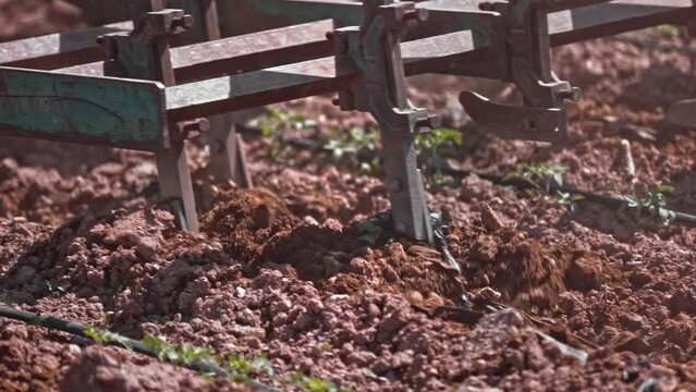 close up of soil aeration with tractor. Blades of a rototiller working the land, agriculture, slow motion close up