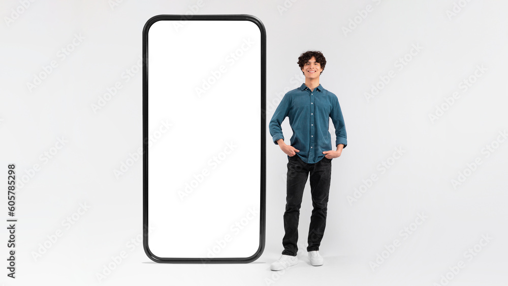 Poster man standing near huge cellphone empty screen on white background