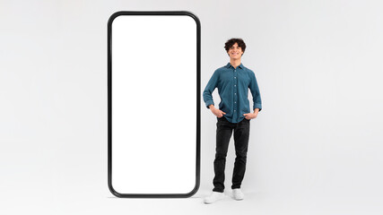 Man Standing Near Huge Cellphone Empty Screen On White Background