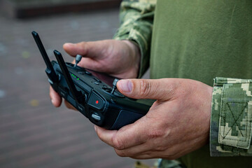 A soldier remotely controls a drone. Control panel in hands.