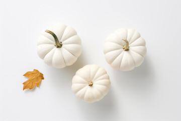 Autumn concept, card or background with three white pumpkins in a row on a white background - flat lay 