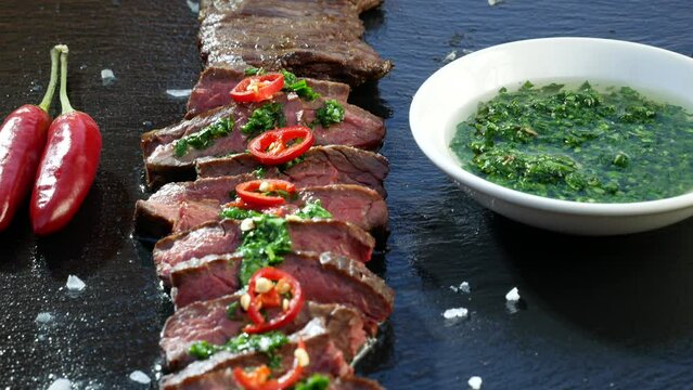 Black stone plate with skirt steak pepper and chimichurri sauce