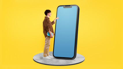 Student Man Touching Huge Phone Empty Screen On Yellow Background