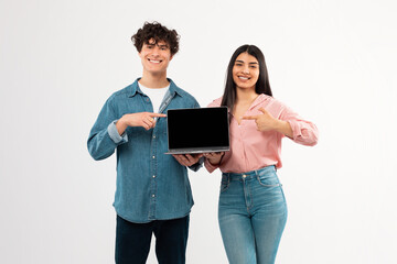 Students Couple Showing Laptop With Blank Screen Over White Background