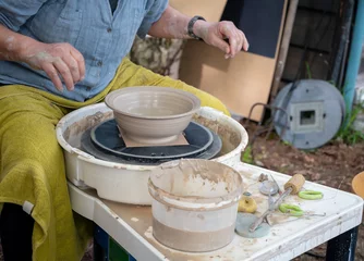 Foto op Canvas Making of mud pot on potters wheel during workshop outdoor © barmalini