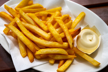 Eating of street or take away food fresh baked french fried potatoes chips with Belgian mayonnaise