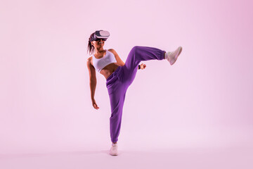 Fitness in digital age. Black woman exercising in the metaverse, wearing virtual reality headset, pink neon background