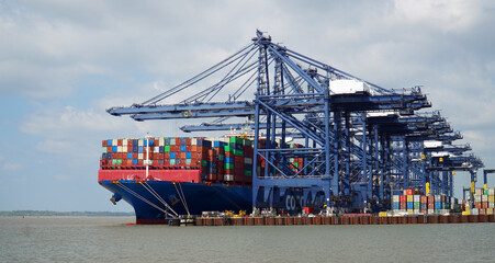 Container ship being loaded and unloaded at Felixstowe docks suffolk  England.