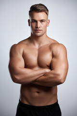 Portrait, man and bodybuilder with arms crossed on studio background, backdrop and topless abs....