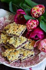 Streusel pie with currant and rose petal filling on a background of tulips.