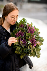 Fototapeta premium Girl florist holding big and beautiful mono bouquet of fresh decorative brassica cabbage