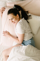 Happy young woman resting on bed with pillow