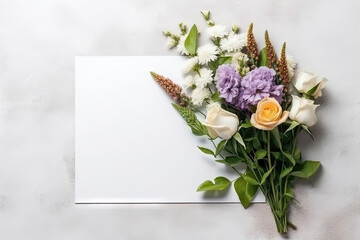 mockup white paper with flower flower arrangement over a grey layflat