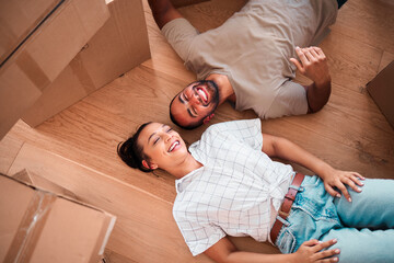 Top view, happy couple and moving into new home on floor, ground and relax from packing boxes. Man,...
