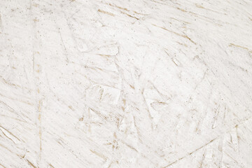 Fiberboard plywood roughly painted with white paint, texture background, glued wood chips