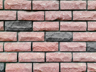 Brickwork of pink and gray bricks, uniform texture background, close-up