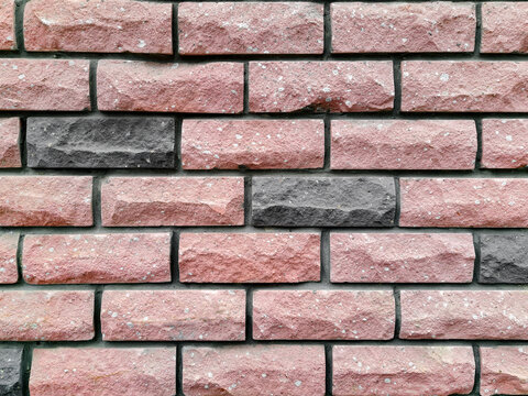 Brickwork of pink and gray bricks, uniform texture background, close-up