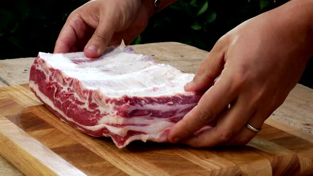 Griller cleans and checks rib rack of beef
