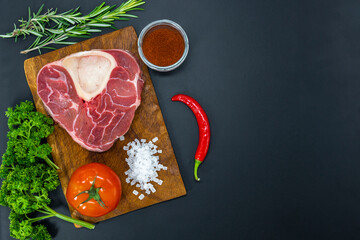 Fresh raw beef steaks ready for grilling, shot from above. Seasonings, vegetables, fruits and herbs.