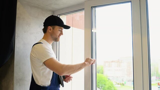 Worker checks system of a window lock. The concept of protecting a child from falling out of windows. Handle with a lock on the window