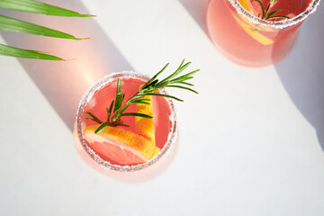 Top view of fresh grapefruit or red orange cocktails, with ice cubes, fresh fruit slices inside and...