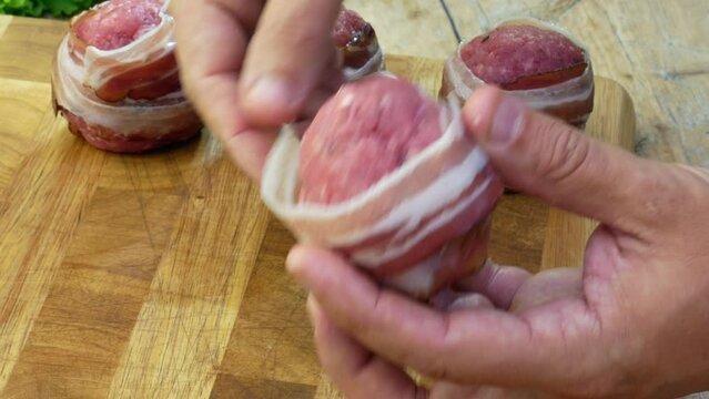 Detail of Preparation of meatballs stuffed with cheese and covered with bacon
