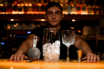 Bar counter with a variety of bar equipment. Blurred bartender's silhouette on background