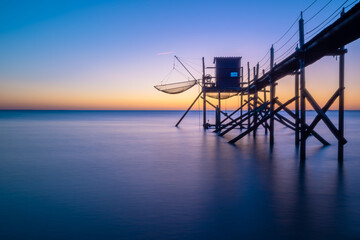Fototapeta na wymiar Fishing hut on stilts coast of Atlantic ocean at sunset near La Rochelle, Charente Maritime, France