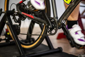 Feet and legs spinning on a chain bicycle in an indoor trainer 