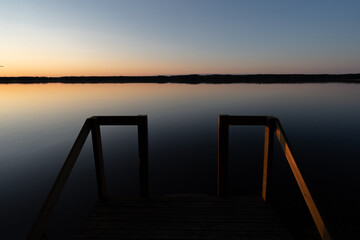 calm lake at sunset with jetty - 605816052