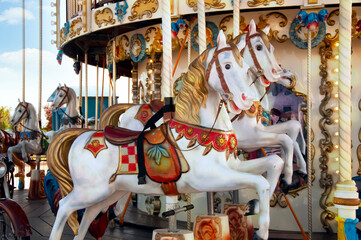 Fototapeta na wymiar A carousel with beautiful white horses. Festival